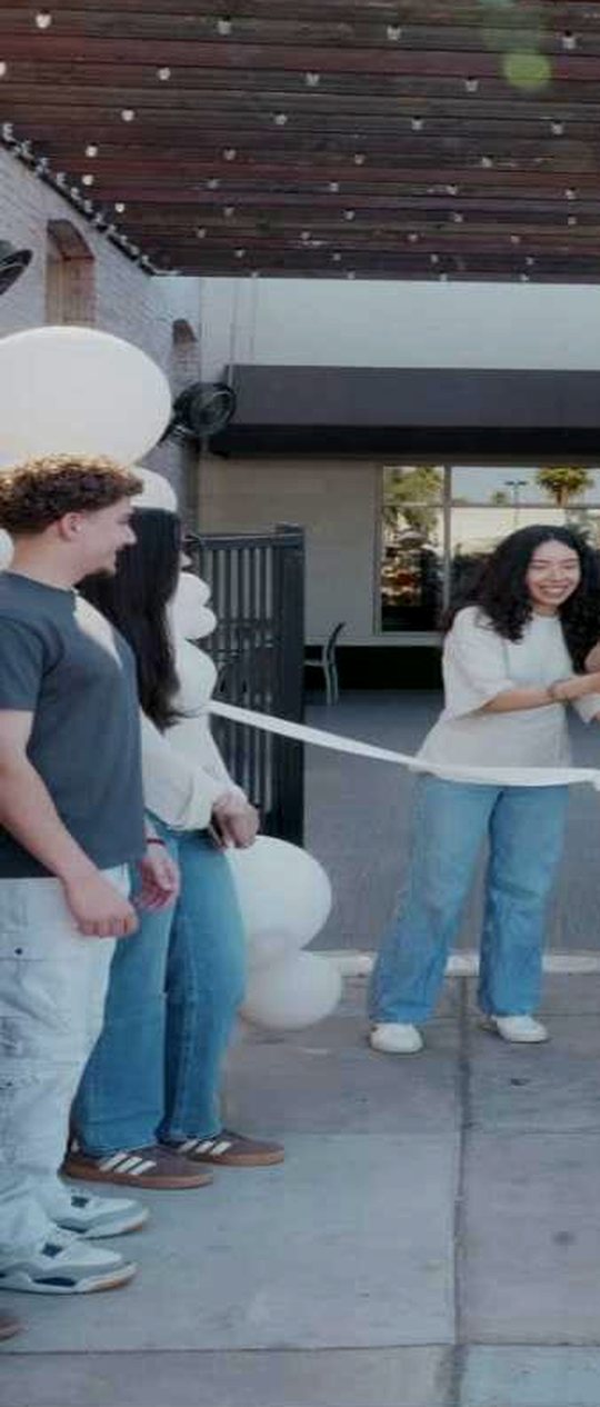 Ribbon cutting outside Princess Pita Midtown with balloons and guests